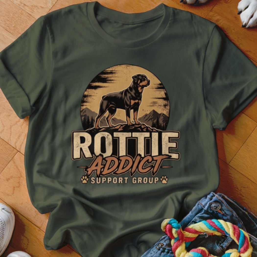 Dark green t-shirt featuring a Rottweiler graphic, mountain sunset backdrop, and text reading Rottie Addict Support Group.