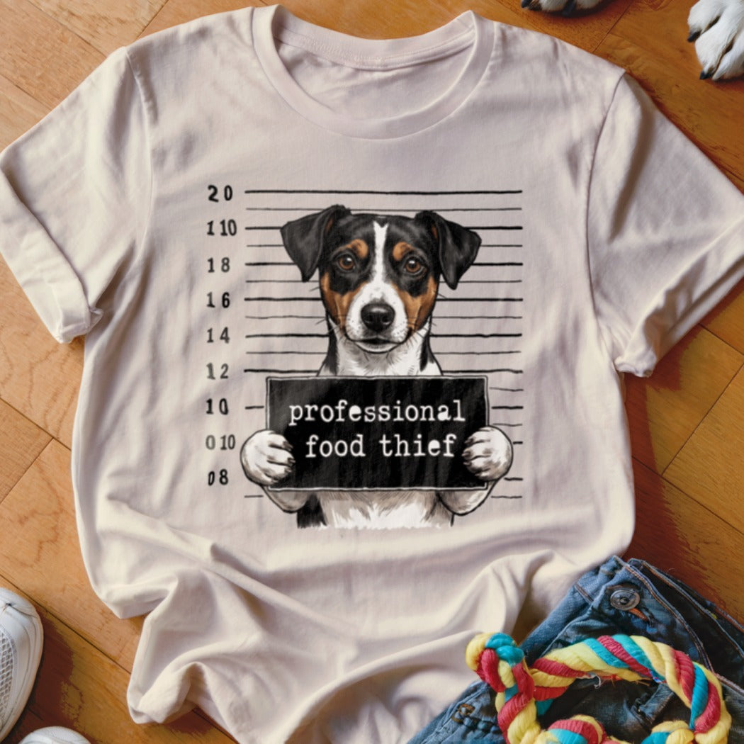 Jack Russell terrier mugshot with sign reading "professional food thief."