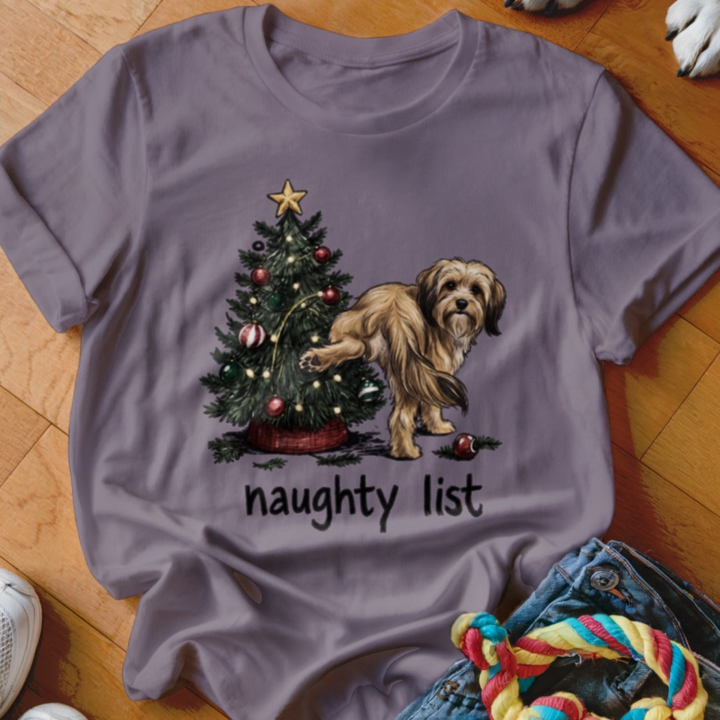 Dog lifting leg on Christmas tree with "naughty list" text.