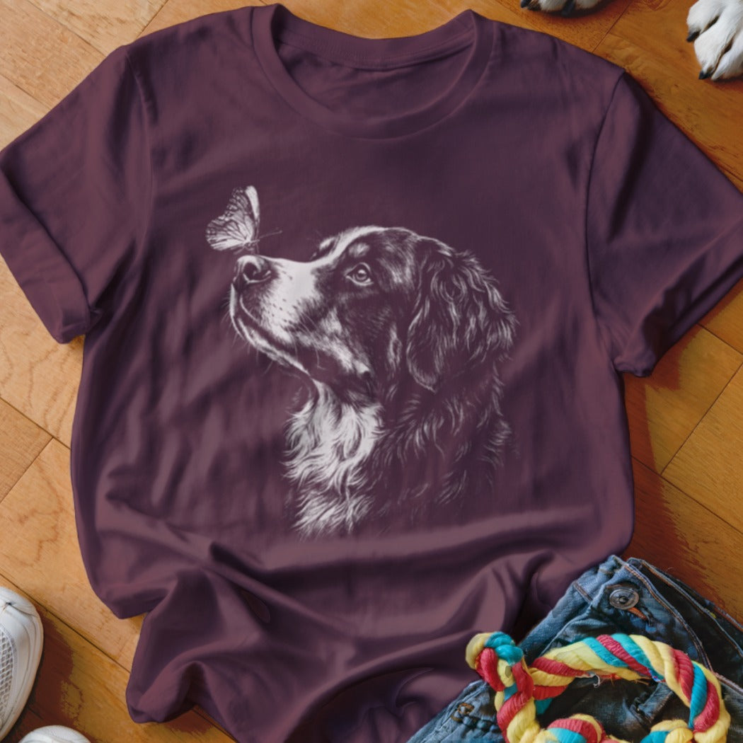 A dark purple t-shirt featuring a white line art illustration of a dog looking at a butterfly.