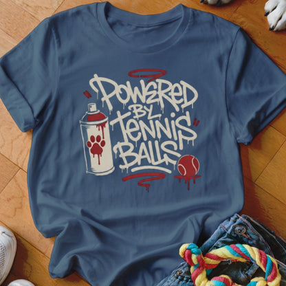 Blue t-shirt with "Powered by Tennis Balls" in graffiti style, spray can graphic and a tennis ball.