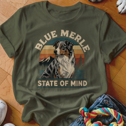Blue Merle Australian Shepherd graphic on olive green t-shirt with sunset and mountains.