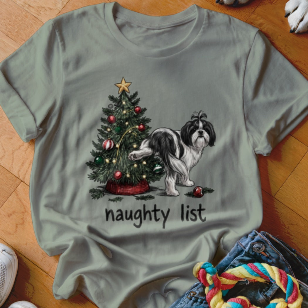 Olive green t-shirt featuring a Shih Tzu puppy urinating on a Christmas tree with text reading naughty list.