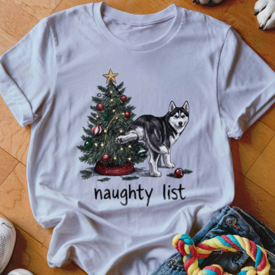 A white t-shirt featuring a graphic of a husky urinating on a Christmas tree with the text naughty list.