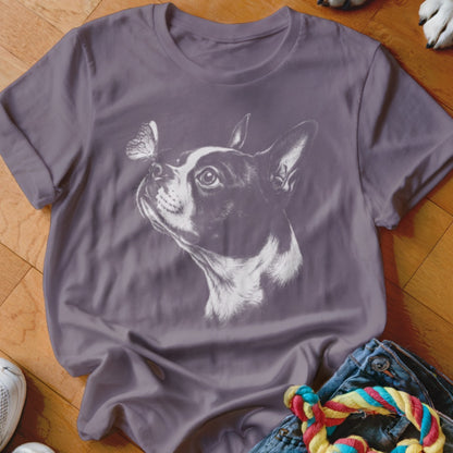 A purple short-sleeved t-shirt printed with a white sketch of a Boston Terrier looking at a butterfly on its nose.
