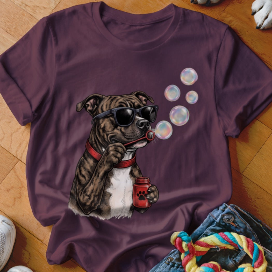 A maroon crewneck t-shirt featuring a graphic of a brindle dog wearing sunglasses and blowing bubbles.