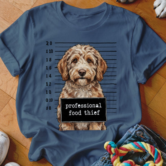 Goldendoodle dog in mugshot with "professional food thief" sign.