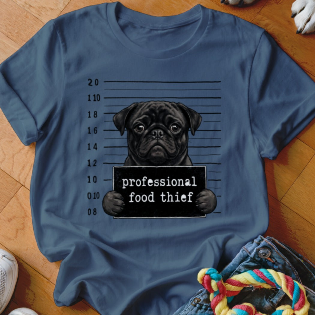 Black pug mugshot graphic with "professional food thief" text on blue t-shirt.