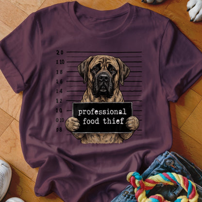 Mastiff dog mugshot with "professional food thief" sign on plum t-shirt.