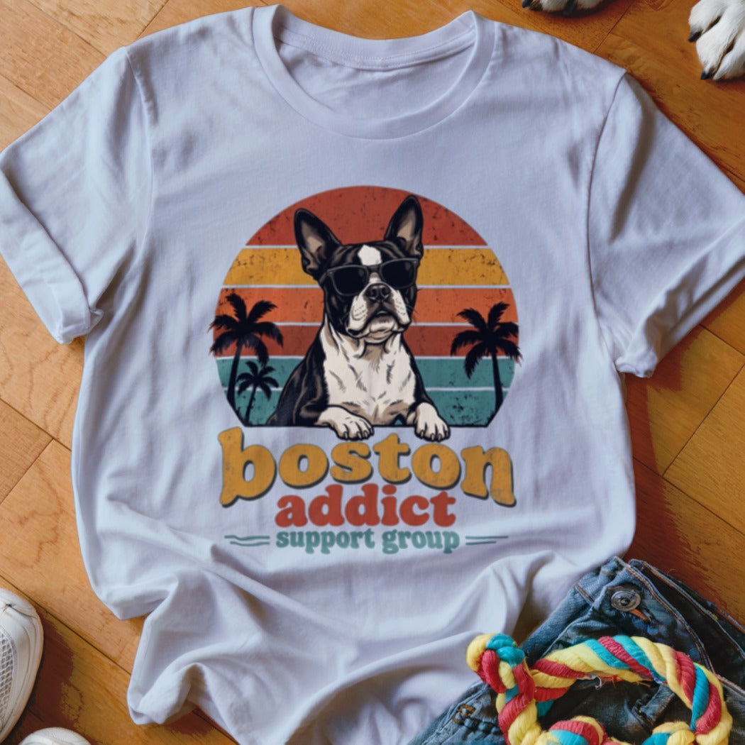 White t-shirt featuring a retro graphic of a Boston Terrier wearing sunglasses against a sunset and palm trees.