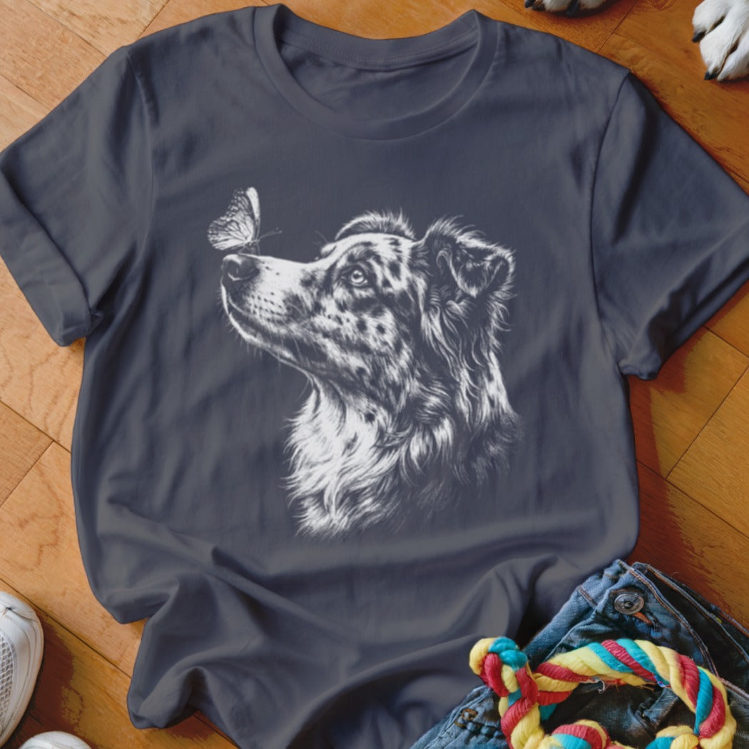 Dark grey short-sleeved t-shirt featuring a white graphic of an Australian Shepherd looking at a butterfly on its nose.