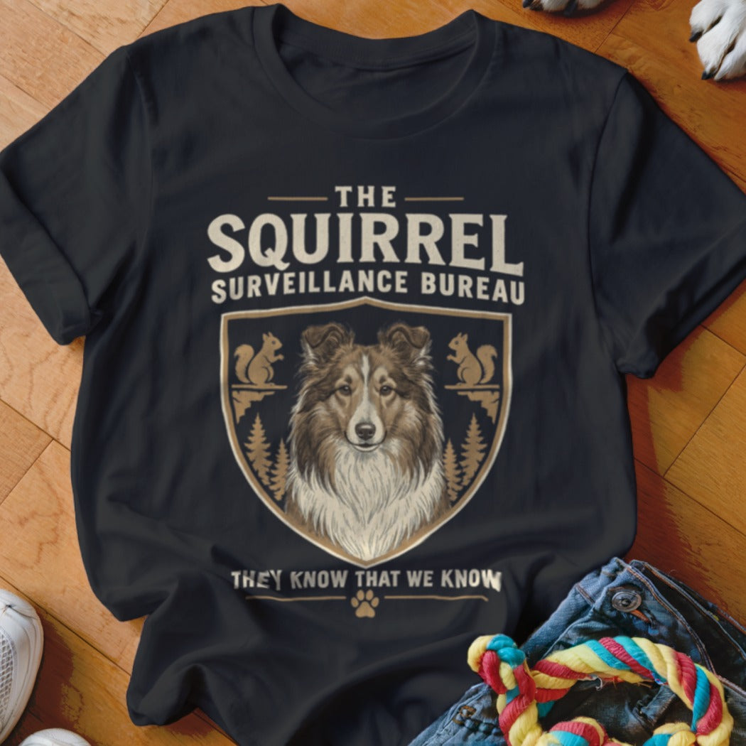 Black t-shirt featuring a graphic of a Sheltie dog inside a crest with squirrel silhouettes.