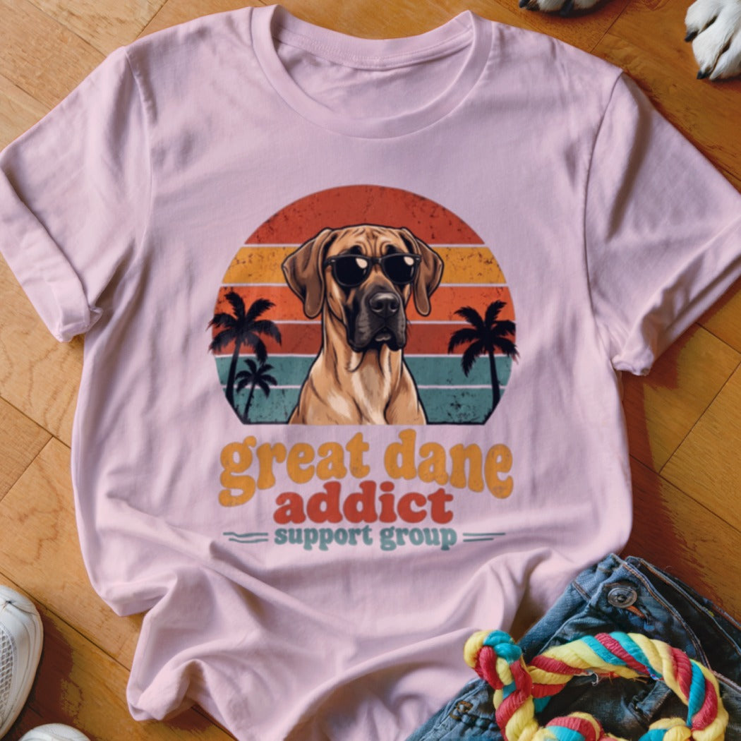 A light pink t-shirt displays a retro sunset graphic with a Great Dane wearing sunglasses and text reading "Great Dane Addict Support Group".