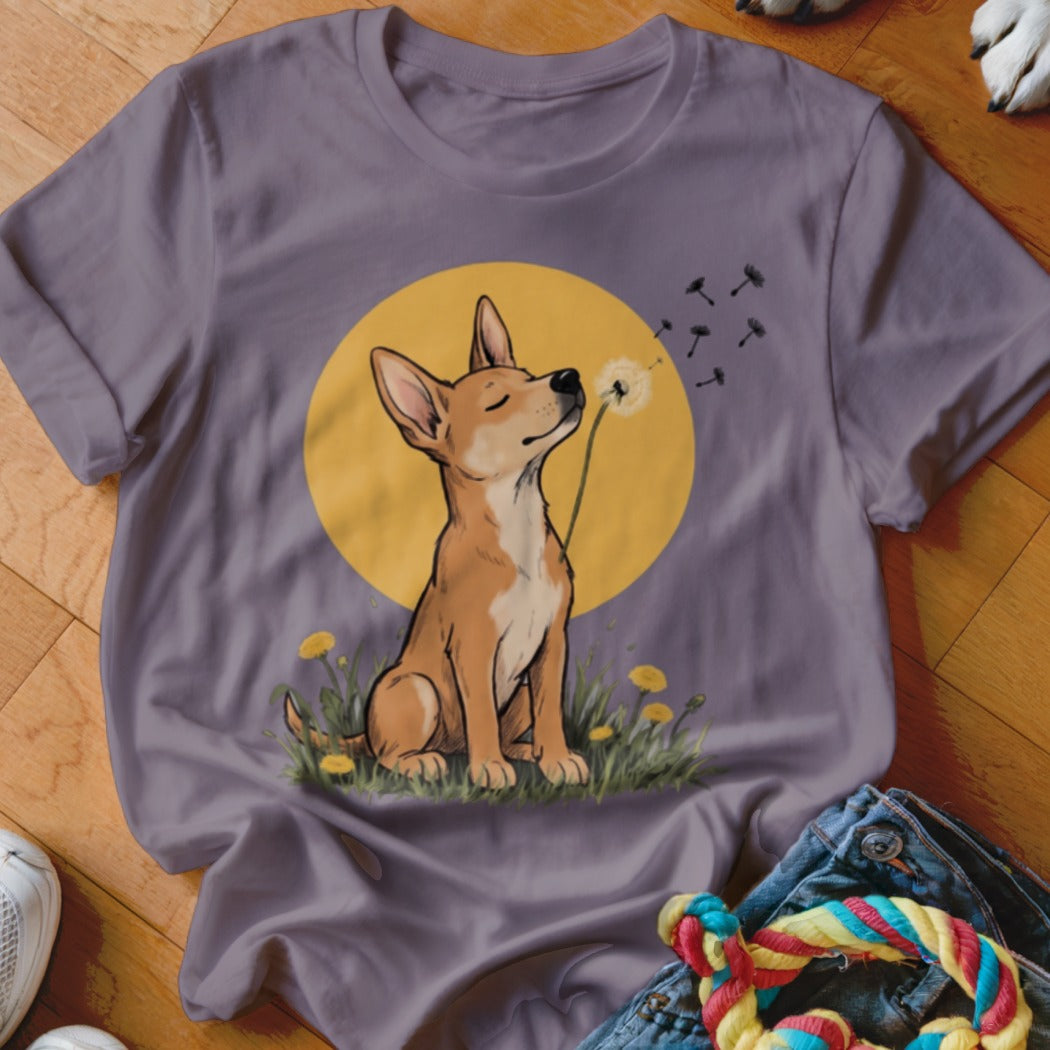 A dark gray t-shirt featuring a cartoon illustration of a dog blowing a dandelion.