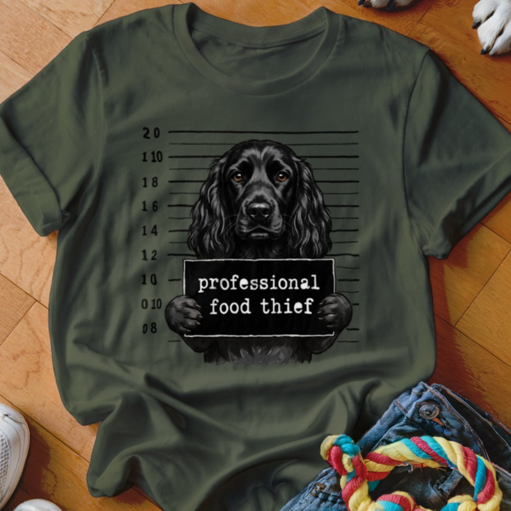 Black dog mugshot with "professional food thief" sign.