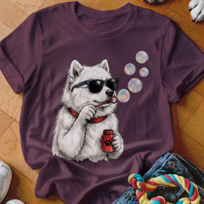 A plum t-shirt featuring a graphic of a white dog wearing sunglasses and blowing bubbles.