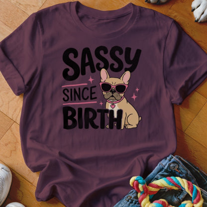 French bulldog wearing sunglasses on a shirt that says "Sassy Since Birth".