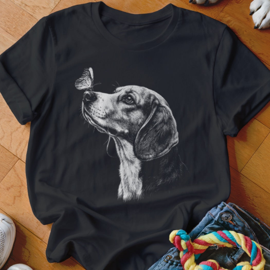A black short-sleeved t-shirt featuring a white graphic of a hound dog looking at a butterfly on its nose.