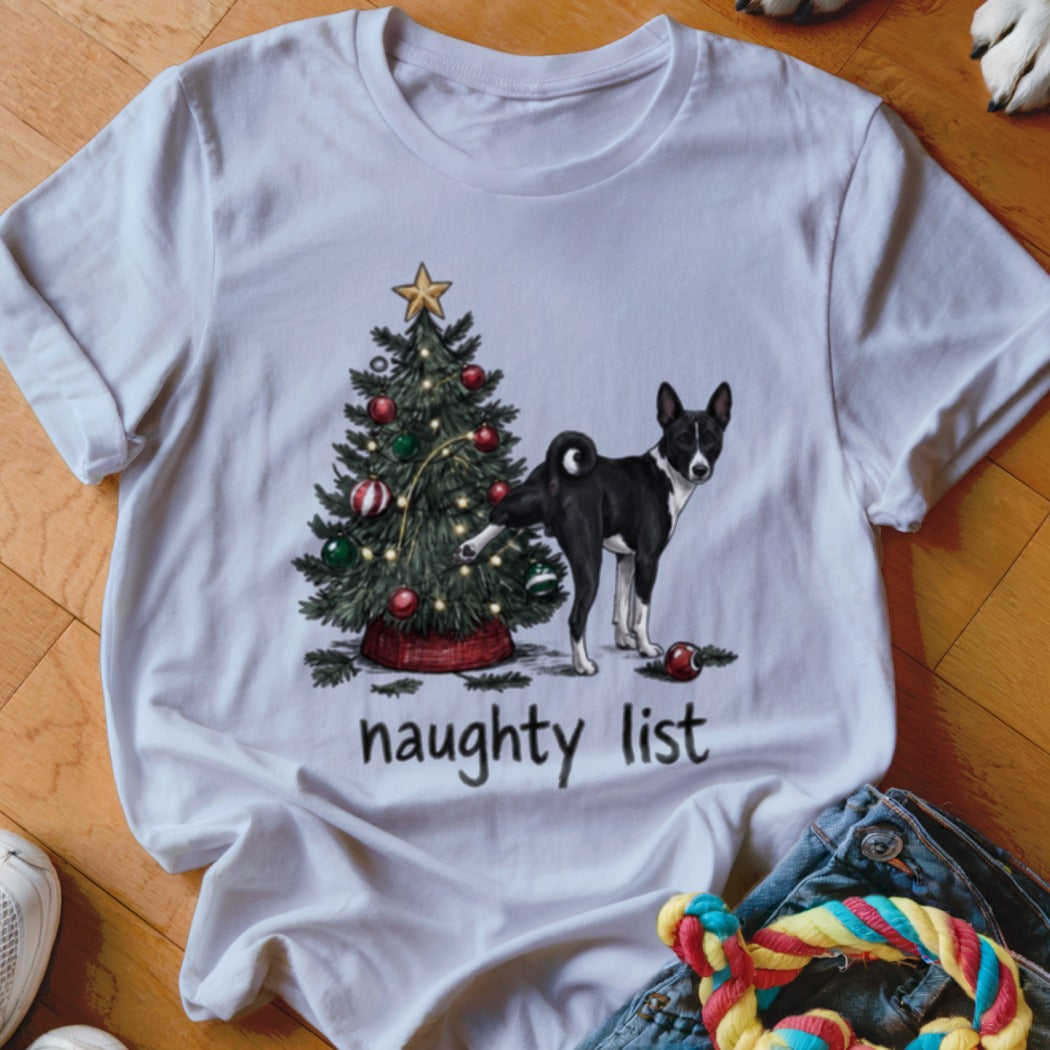 White t-shirt featuring a graphic of a Basenji dog peeing on a Christmas tree with the text naughty list.