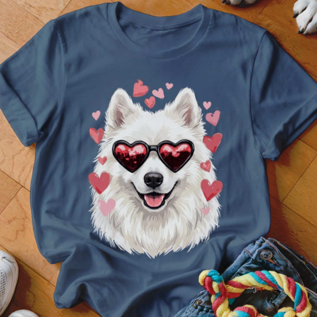 Dark blue t-shirt featuring a graphic of a white fluffy dog wearing heart-shaped sunglasses surrounded by pink hearts.