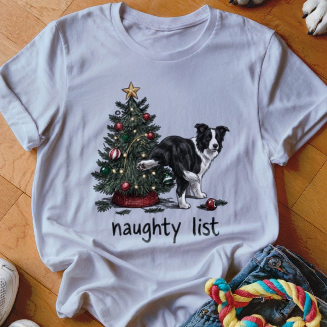 A white t-shirt featuring a graphic of a Border Collie lifting its leg against a Christmas tree, with the text "naughty list".