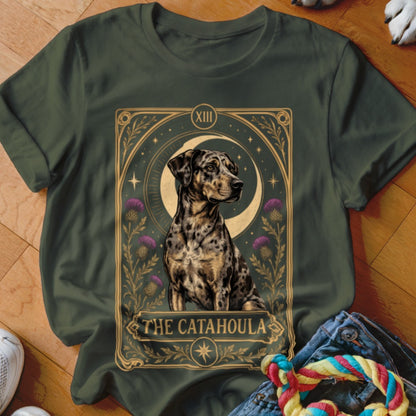 Dark green t-shirt featuring a tarot card graphic of a spotted Catahoula dog, crescent moon, and purple thistles.