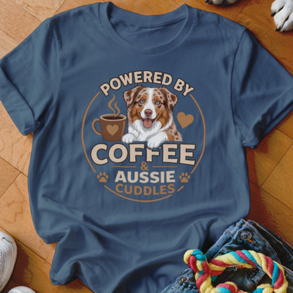 Blue t-shirt featuring a graphic of an Australian Shepherd, a coffee cup, and text reading Powered by Coffee & Aussie Cuddles.