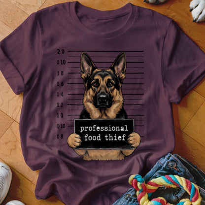 German Shepherd mugshot with text "professional food thief" on a maroon t-shirt.