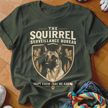 Dark green t-shirt featuring a graphic with a German Shepherd, squirrels, and text reading The Squirrel Surveillance Bureau.