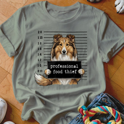 Shetland Sheepdog mugshot with "professional food thief" sign.