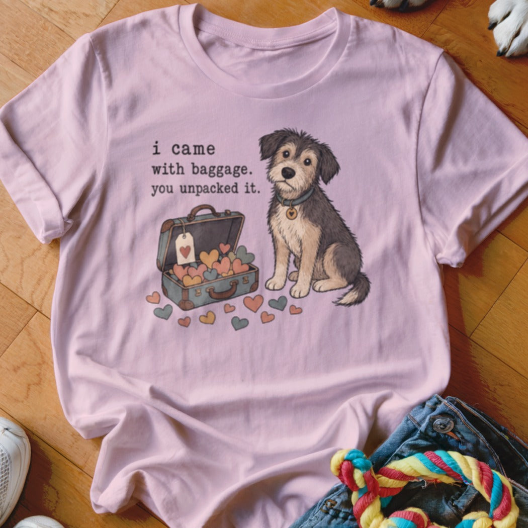 Pink t-shirt with artwork of a dog, open suitcase with hearts, and text "i came with baggage. you unpacked it."