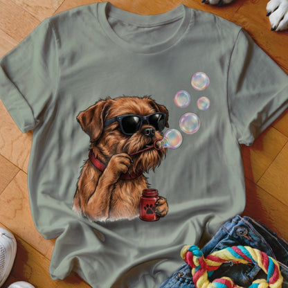 A sage green t-shirt featuring a graphic of a brown dog wearing sunglasses and blowing soap bubbles.