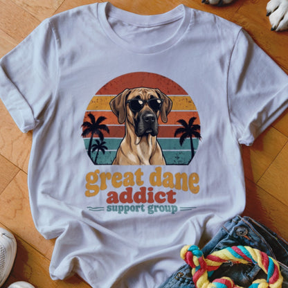 White t-shirt with a retro sunset graphic featuring a Great Dane wearing sunglasses and palm trees.