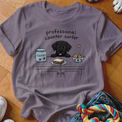 Black lab puppy cartoon with text "professional counter surfer," cookies, and sandwich.