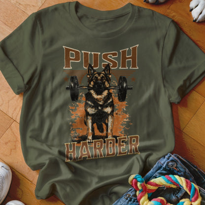 German Shepherd holding barbell with text "PUSH HARDIR" on olive shirt.