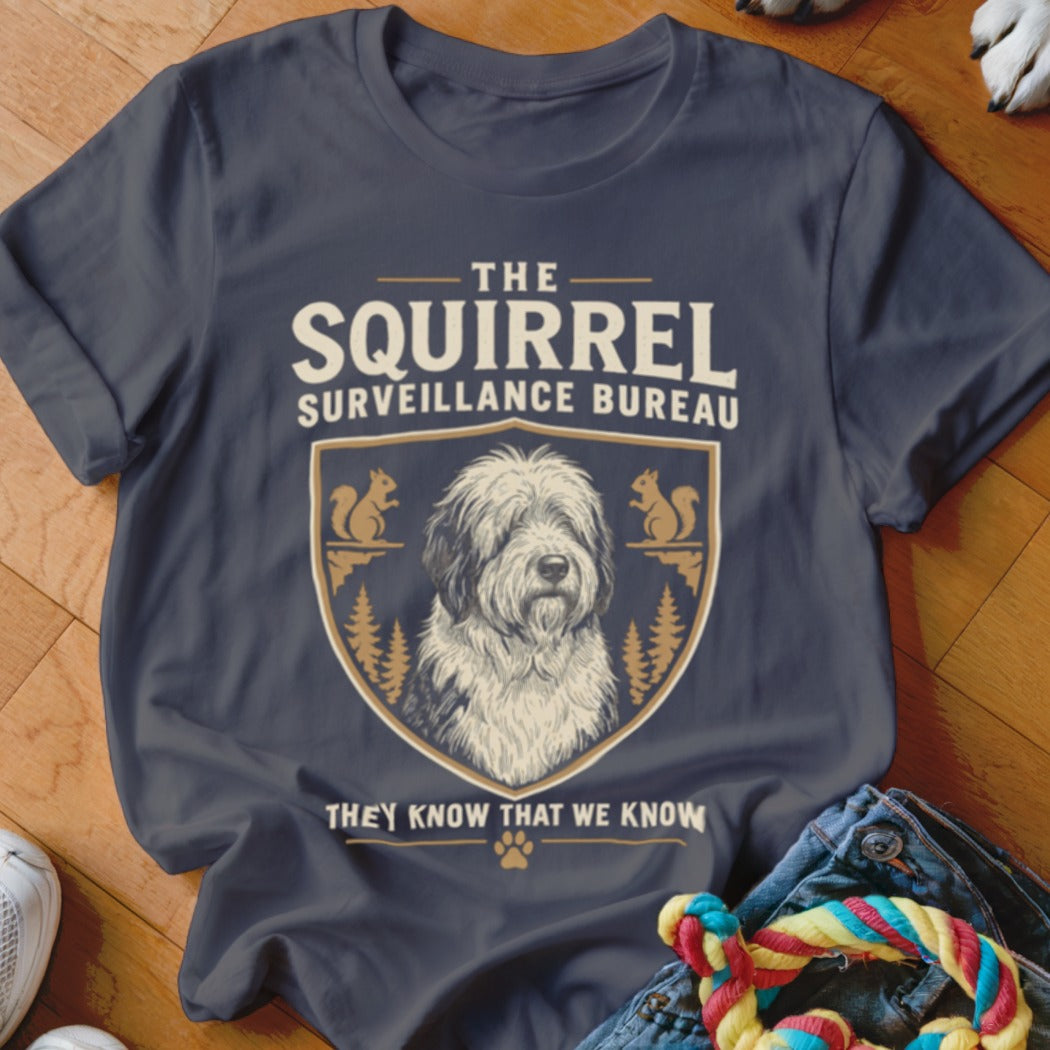Dark grey t-shirt featuring a graphic that reads The Squirrel Surveillance Bureau and an Old English Sheepdog illustration inside a shield emblem.