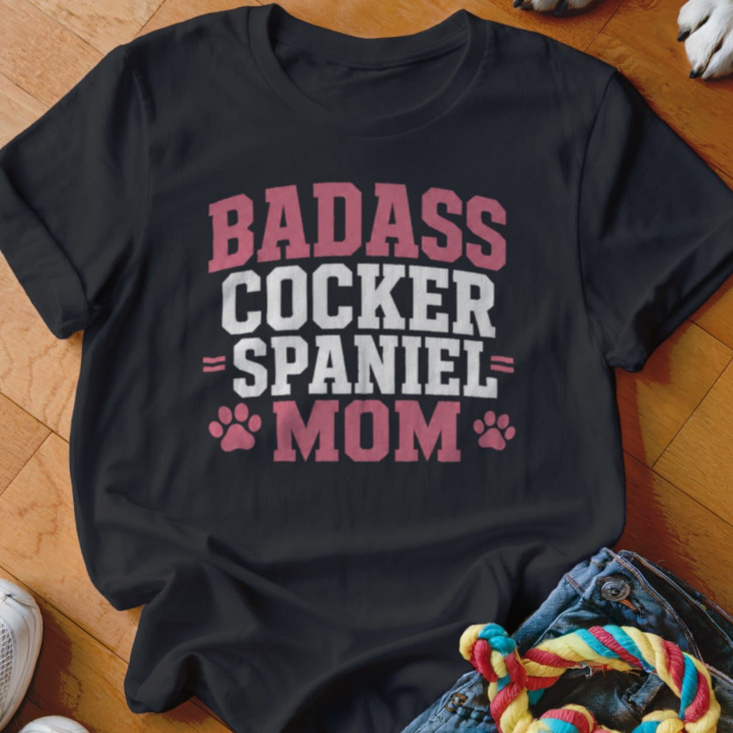 Black t-shirt with "BADASS COCKER SPANIEL MOM" text and paw prints.