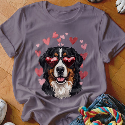 A purple t-shirt features a Bernese Mountain Dog wearing heart-shaped sunglasses, surrounded by pink hearts.
