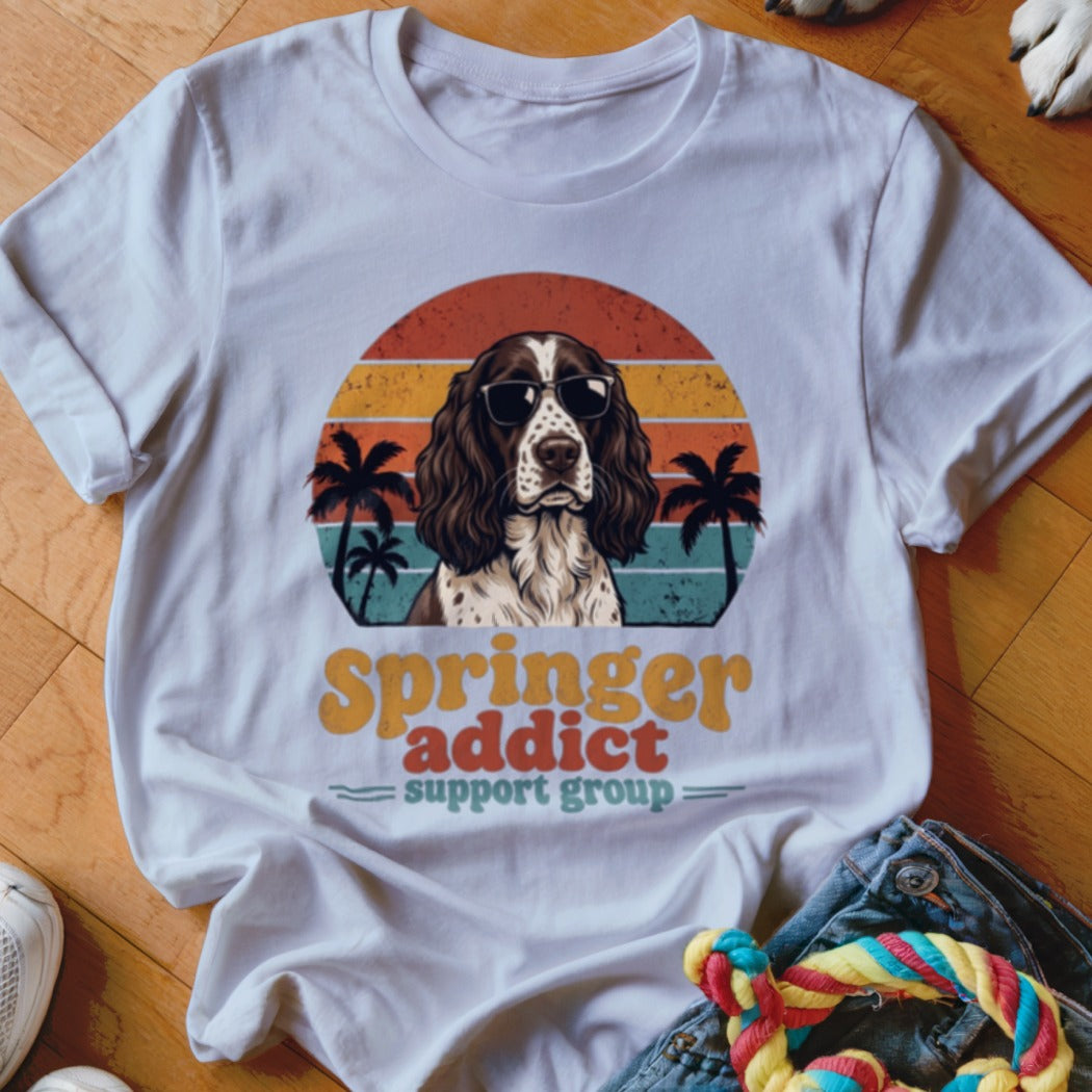 White t-shirt with a retro-style graphic of an English Springer Spaniel wearing sunglasses against a sunset.