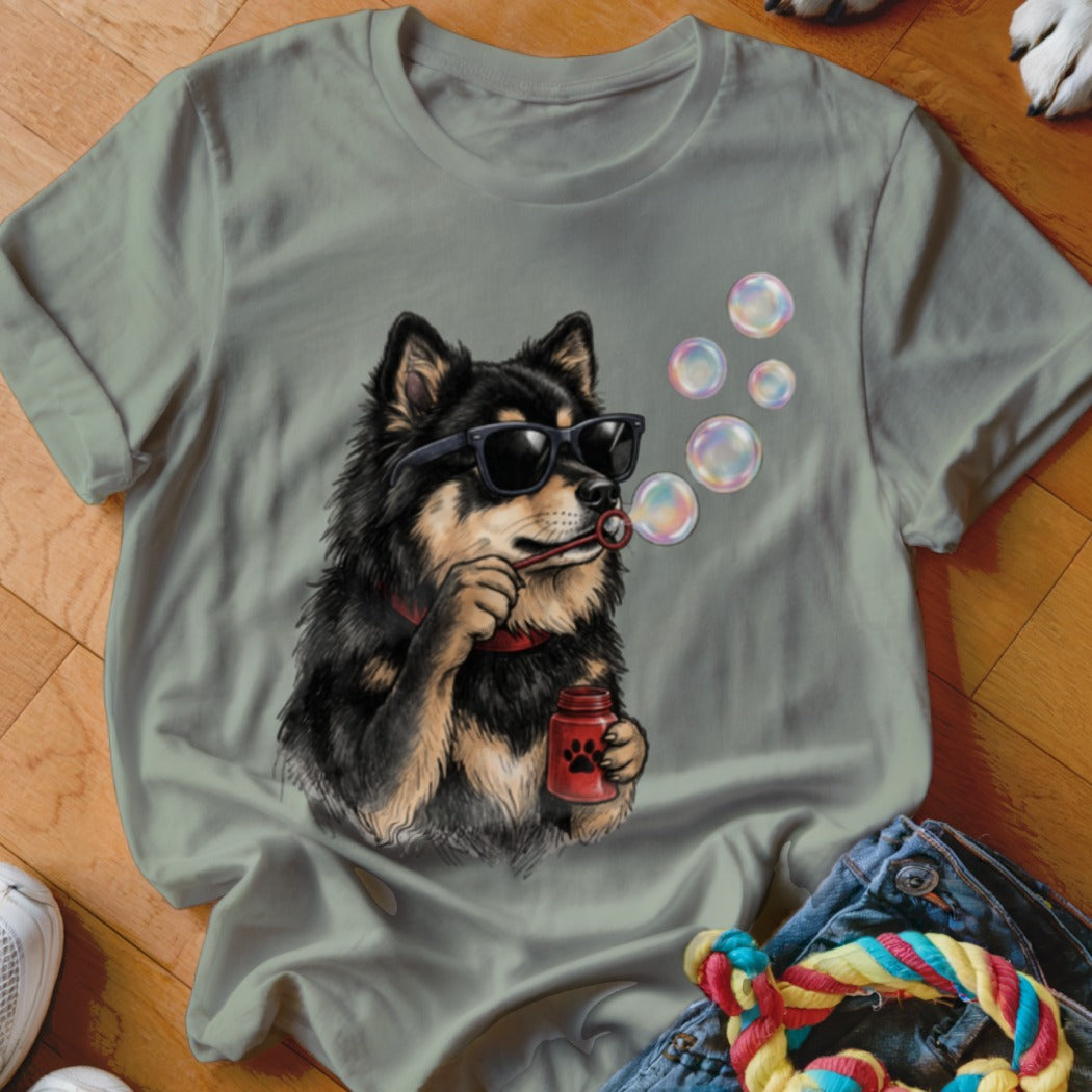 An olive green t-shirt features a graphic of a black and tan dog wearing sunglasses and blowing bubbles.
