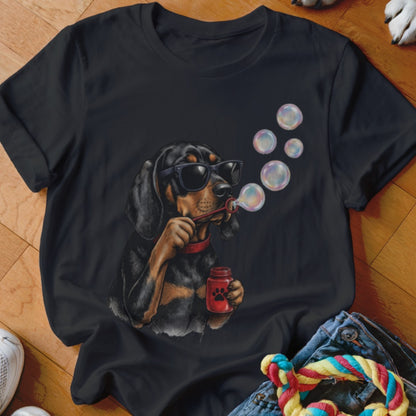 A black t-shirt featuring a graphic of a dog wearing sunglasses and blowing soap bubbles.