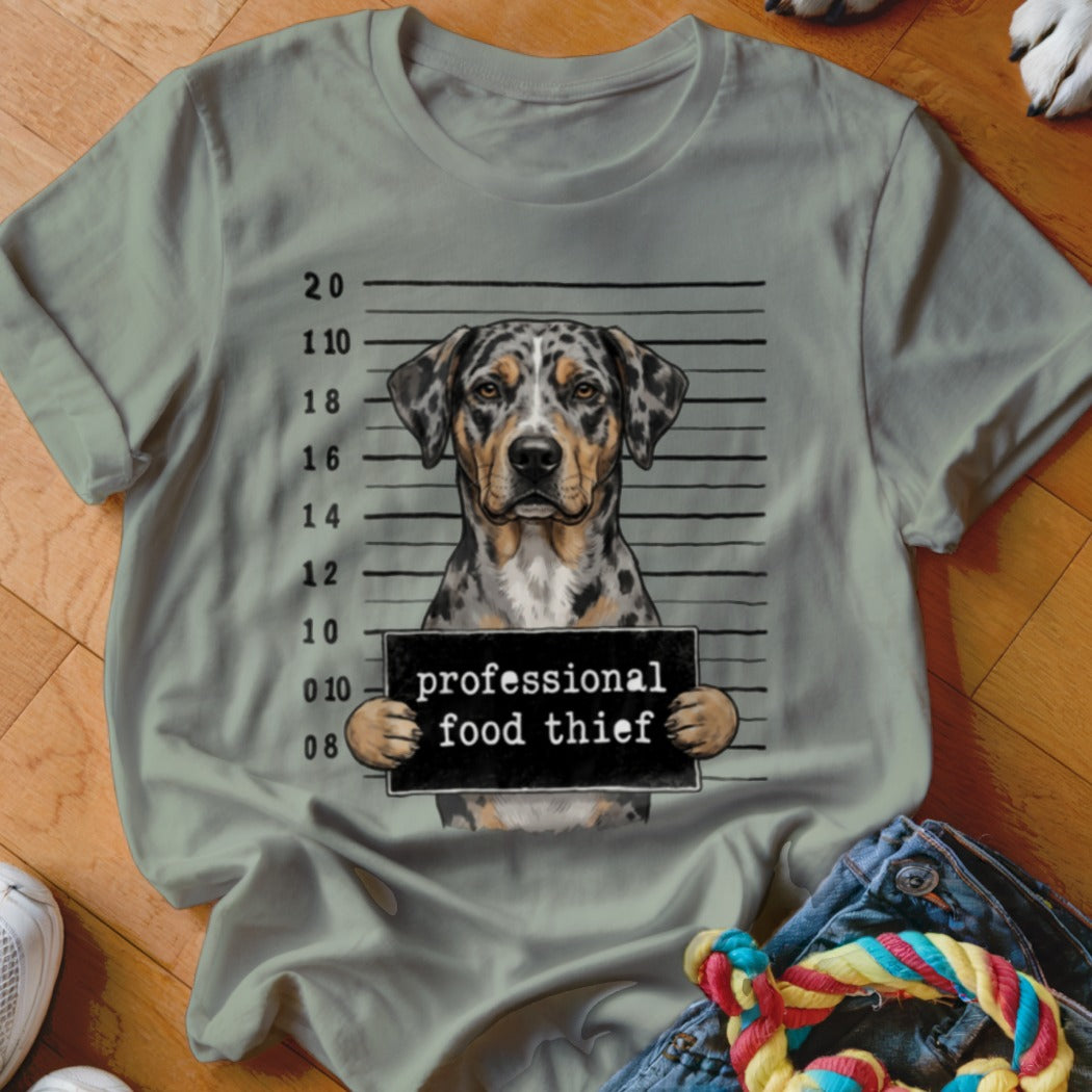 A Catahoula dog mugshot with the sign "professional food thief".