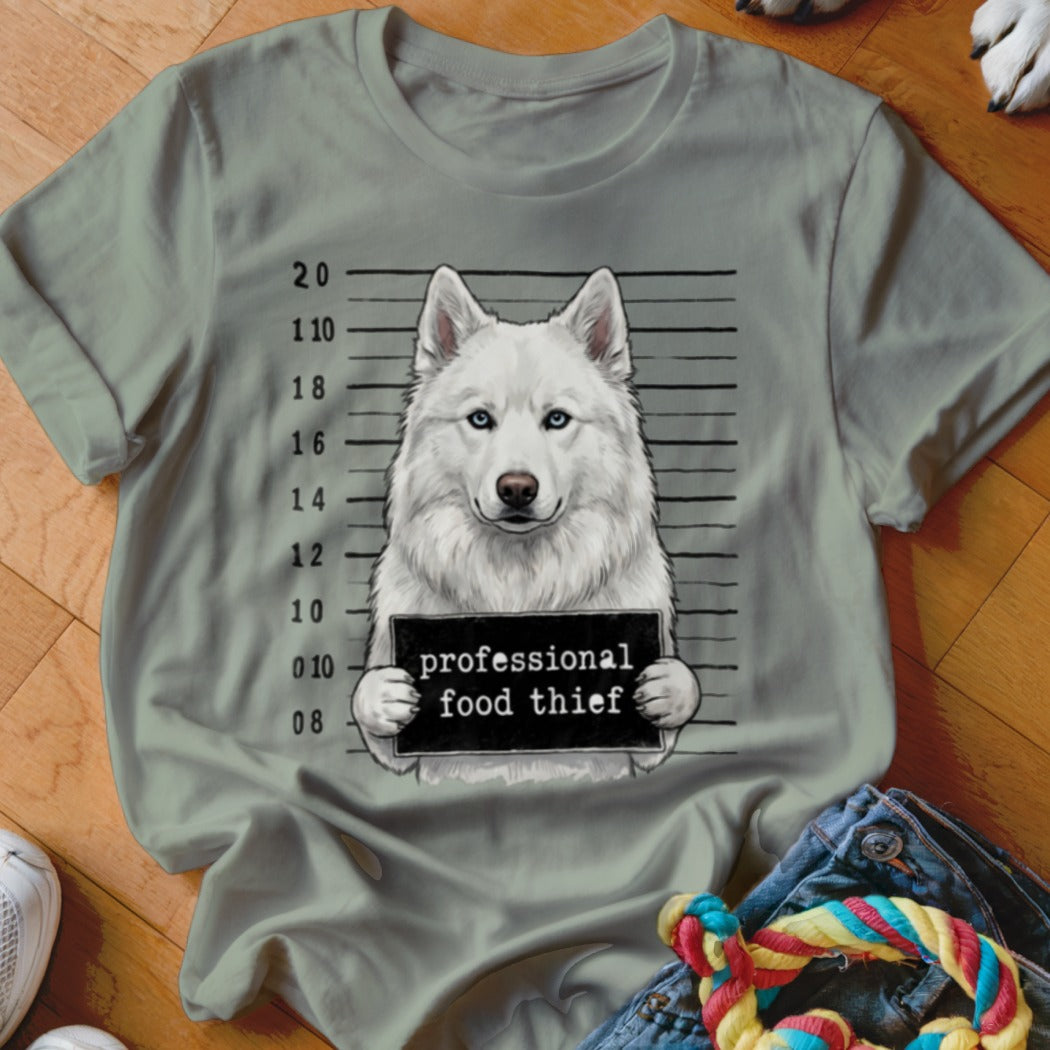 White husky mugshot with "professional food thief" sign.