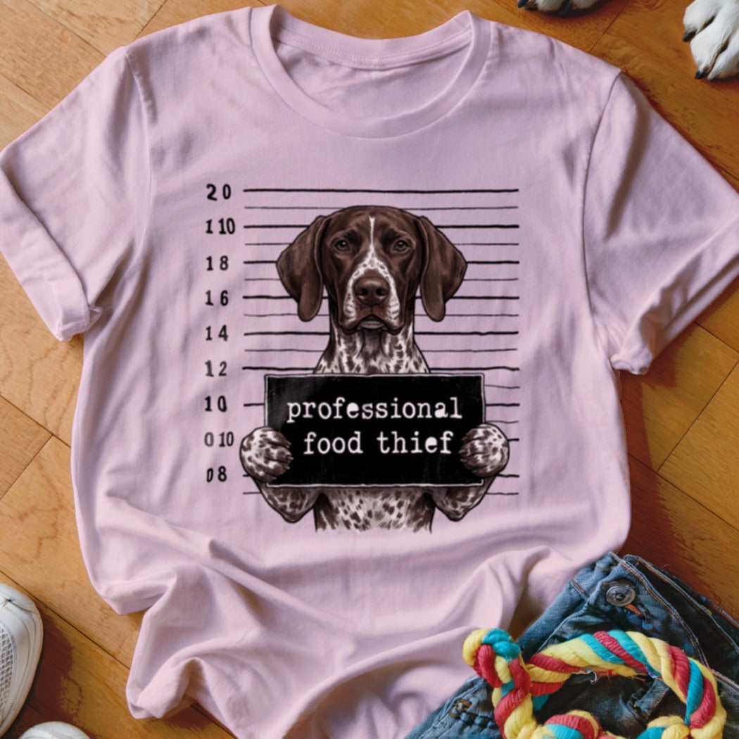 German Shorthaired Pointer in mugshot holding "professional food thief" sign.