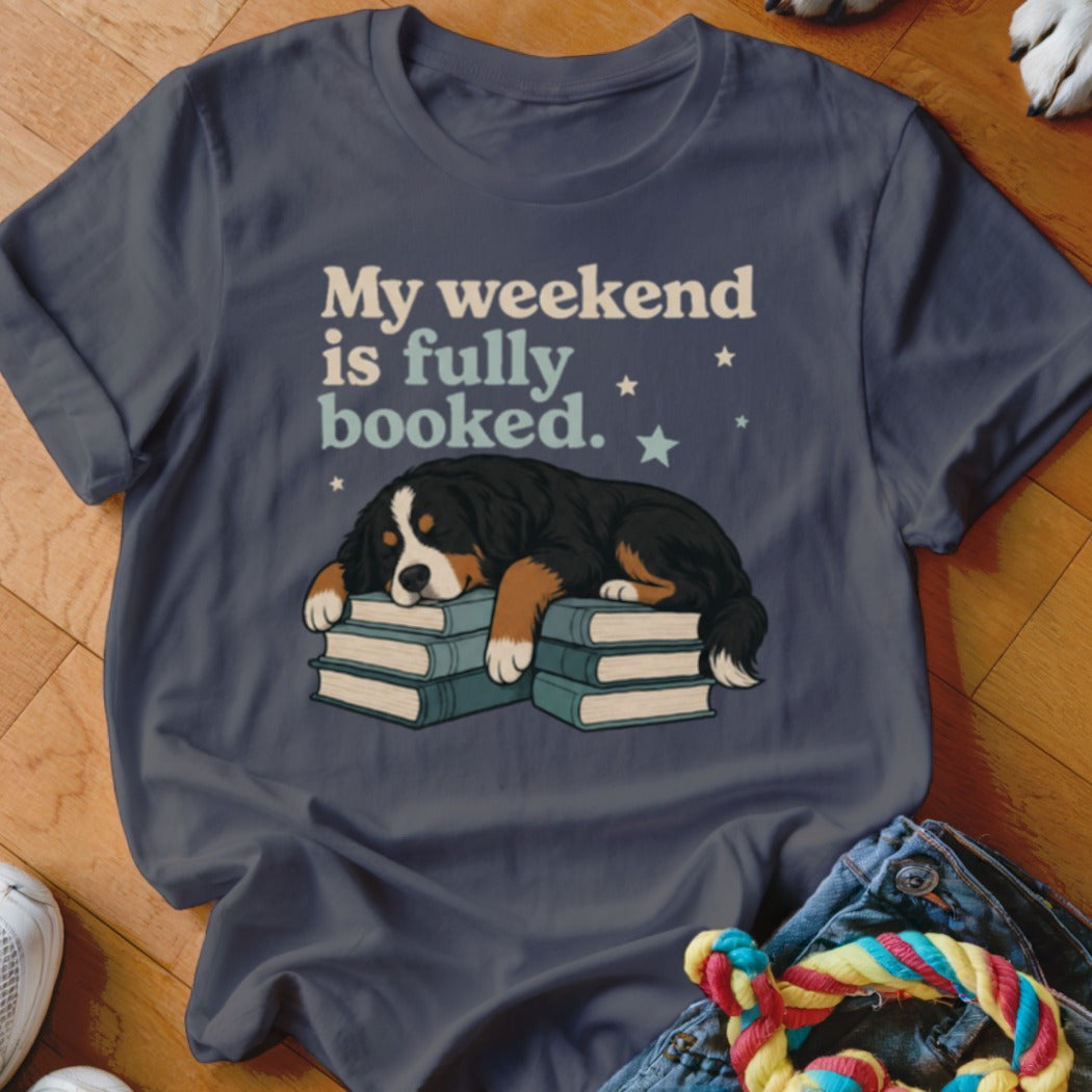 Bernese Mountain Dog sleeping on books with text "My weekend is fully booked."