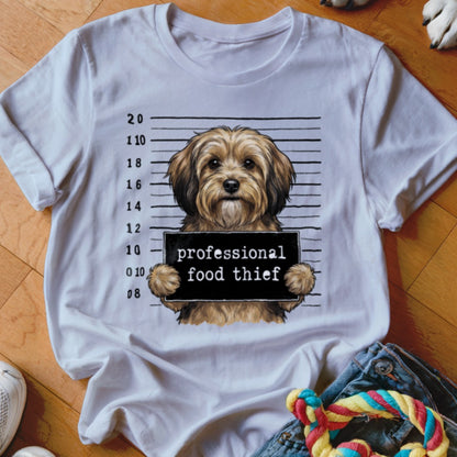 White t-shirt with a dog in a mugshot holding a sign that says "professional food thief".