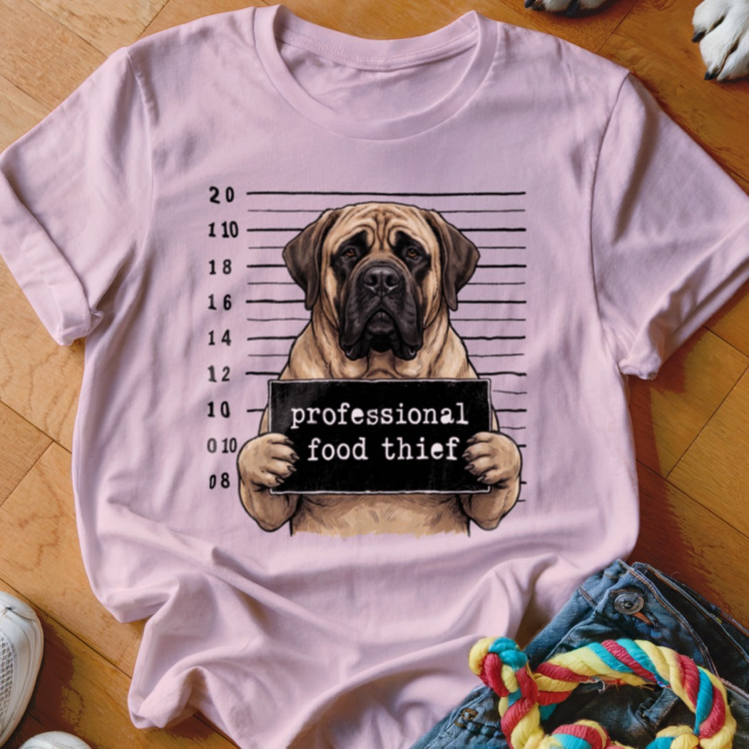 Mastiff dog mugshot with "professional food thief" sign on a pink t-shirt.