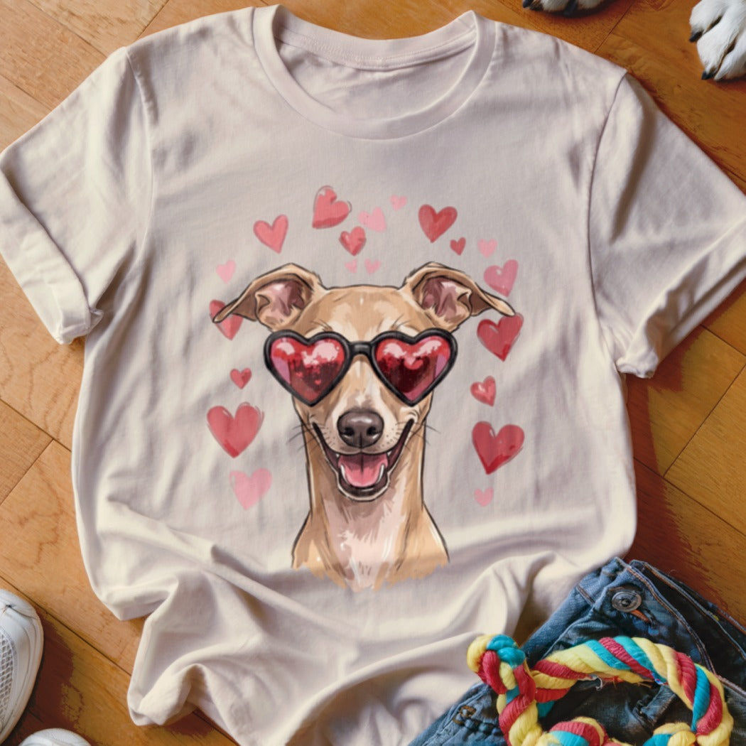 A cream-colored t-shirt featuring a graphic of a tan dog wearing heart-shaped sunglasses surrounded by pink hearts.