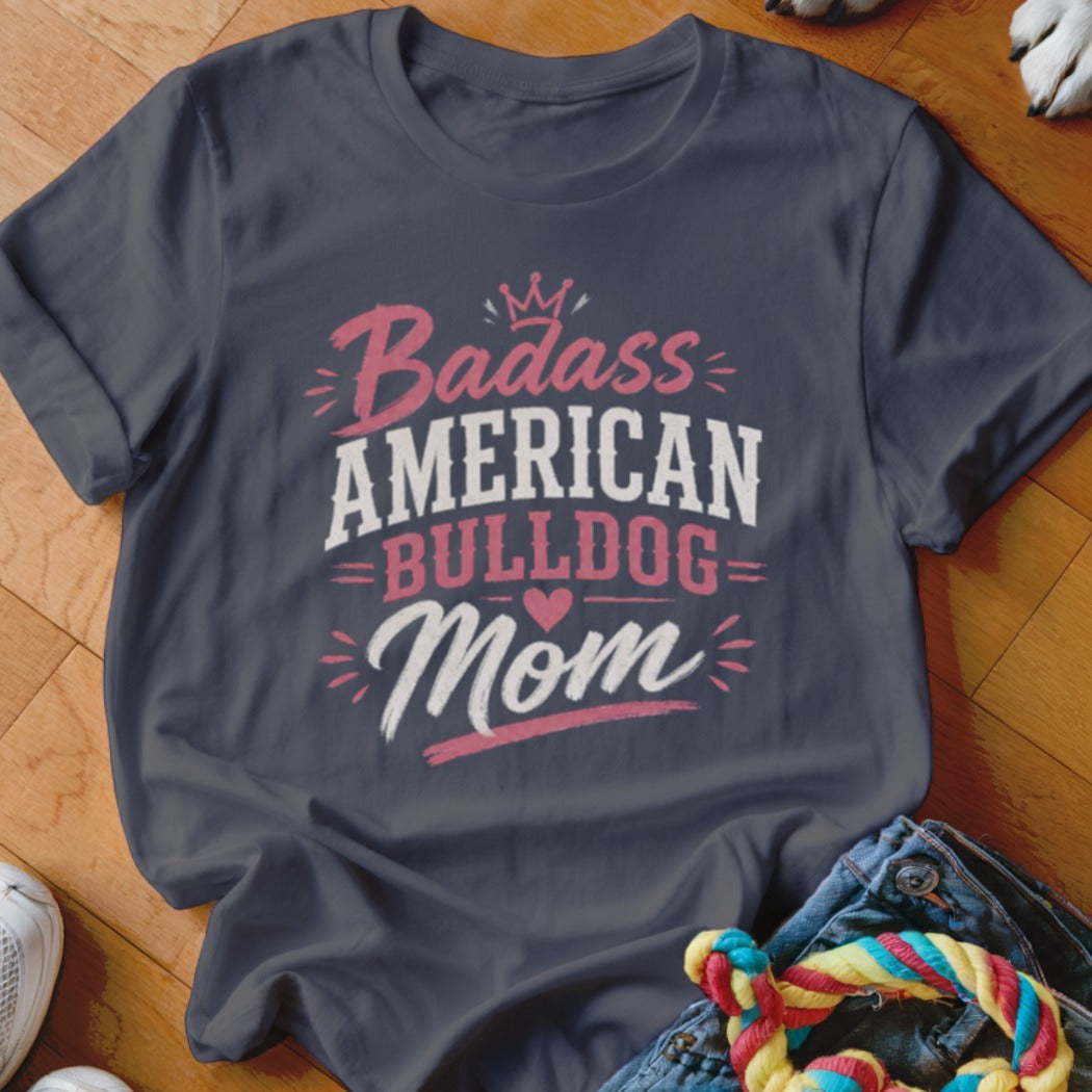 Dark blue t-shirt with "Badass American Bulldog Mom" text and crown graphic.