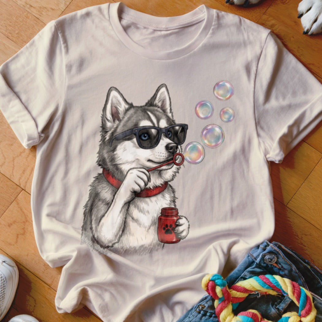 Light beige crewneck t-shirt featuring a graphic of a husky wearing sunglasses and blowing soap bubbles.